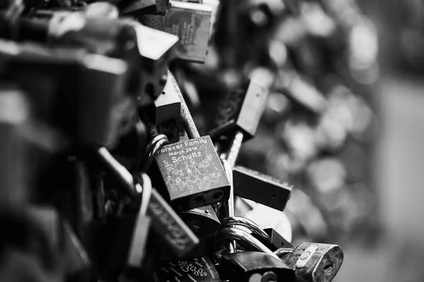 Cadeados pendurados em cerca de arame na ponte — Fotografia de Stock