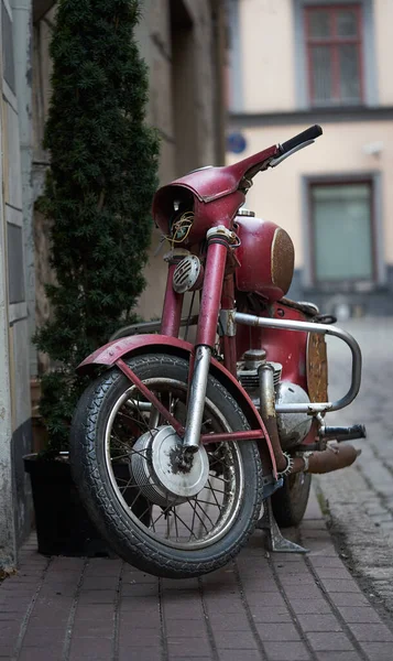 Old abandoned red motorbike at old town street. — Stock Photo, Image