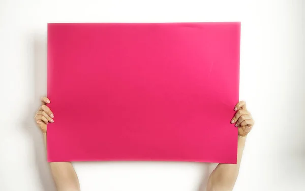 Una gran hoja de papel rojo en sus manos sobre un fondo blanco — Foto de Stock