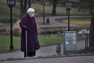 10-10-2019 Riga, Letonya Yaşlı bir kadın caddeyi geçiyor