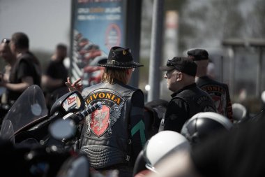 24-04-2019 Riga, Letonya. Dövmeli motorcu diğer motorcularla konuşuyor.