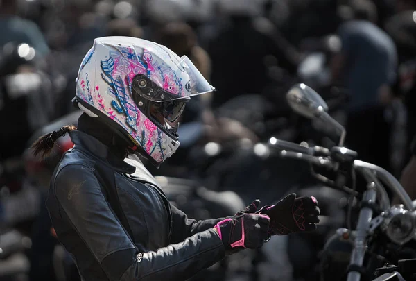 24-04-2019 Riga, Letonia. Chica motorista en una chaqueta de cuero y casco en una motocicleta —  Fotos de Stock