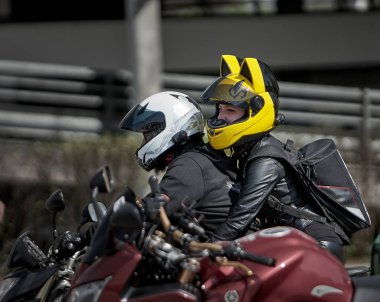 24-04-2019 Riga, Letonya Morsikletçisi ve kulaklı yolcu.