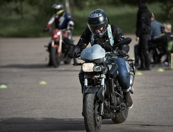 Заручний мотоцикліст в чорному їздить на своєму суперспортивному мотоциклі. М'який фокус. Lens flare 05-08-2019 Рига, Латвія — стокове фото