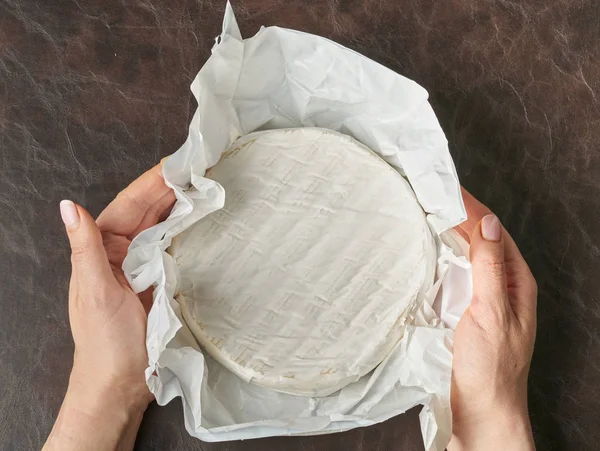 Camembert-Käse rund um den Frieden in Frauenhänden — Stockfoto