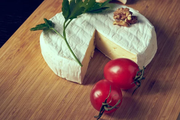 Sýr a rajčata na dřevěném stole — Stock fotografie
