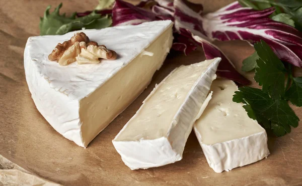 Branco delicioso queijo camambert caseiro em um servo placa de madeira — Fotografia de Stock