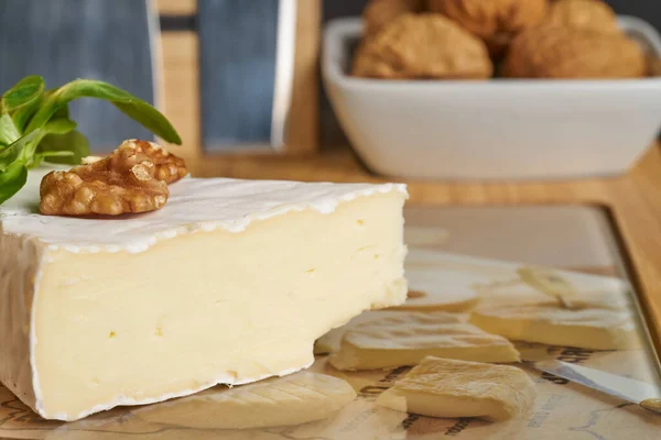 Nahaufnahme von Käse und Walnüssen auf Holzkäseplatte. — Stockfoto