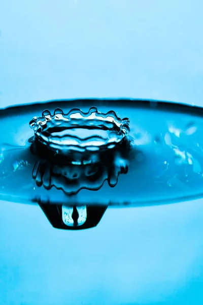 Σταγόνα νερό βουτιά σε ένα γυάλινο μπλε χρώμα — Φωτογραφία Αρχείου