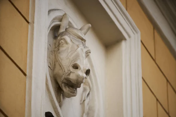 Old horse head sculpture made of stone at entrance of a house