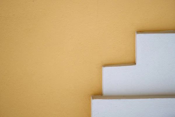 Background of old yellow painted wall and white stairs — Stok fotoğraf