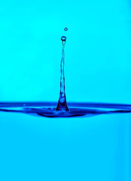 Брызги воды в стакане синего цвета — стоковое фото