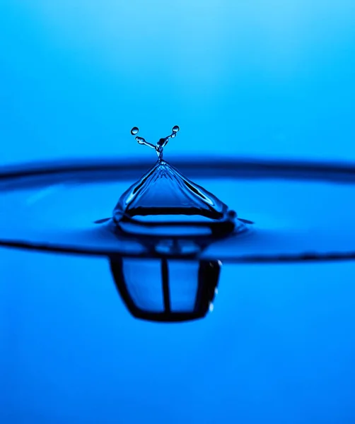 Брызги воды в стакане синего цвета — стоковое фото