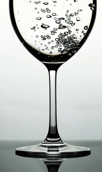 Hell vann i et glass mot lyseblå bakgrunn – stockfoto