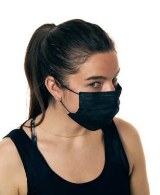 Beyaz bir arka planda, cerrahi maske takan güzel bir kadının yakın plan portresi..