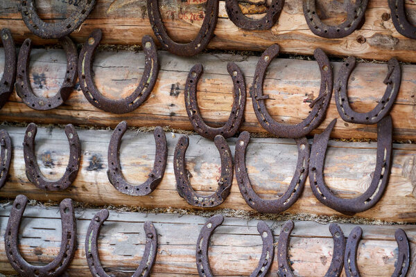 Old rusty horseshoe on a wooden background.