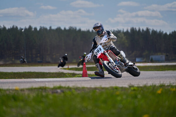 10-05-2020 Ropazi, Latvia Motorcyclist at supermoto rides by empty asphalt road