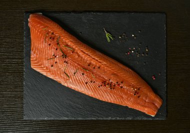 Koyu arkaplanda çiğ somon fileto, vahşi Atlantik balığı..