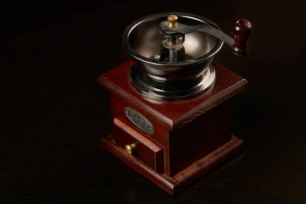 Manual coffee grinder for grinding coffee beans. Black background. Vintage coffee grinder