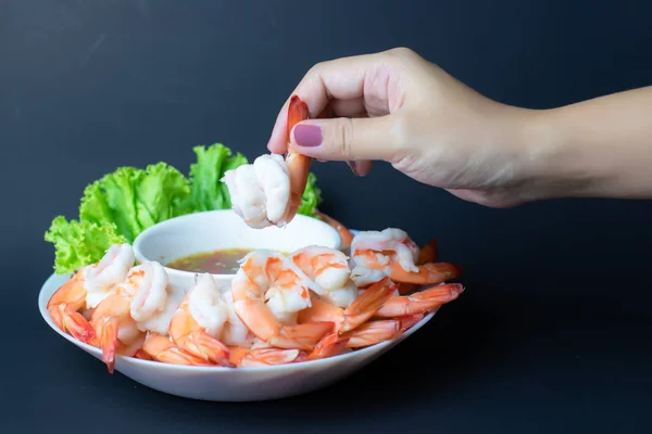 Haşlanmış karidesi tutup sosu beyaz tabağa batırmak..