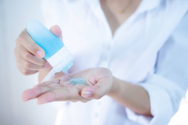 El dezenfektanı kullanan kadın elleri. Alkol jeli pompası. Beyaz arka plan, Corona virüsünden günlük koruma veya COVID-19 konsepti.