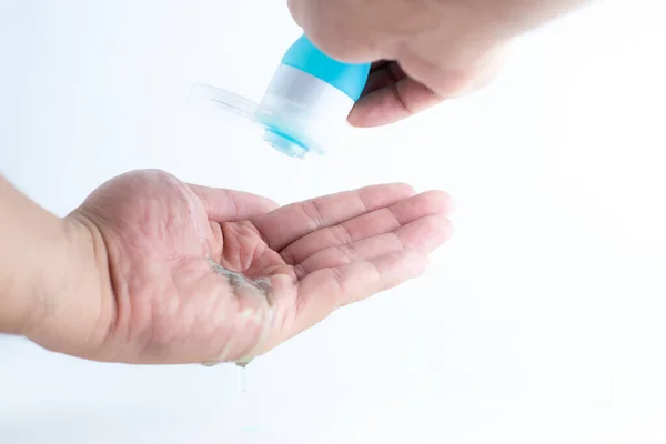 El temizleme jeli. Bir elin ellerine dezenfekte edici el jeli dökmek. Alkol kullanarak ellerdeki mikropları temizlemek..