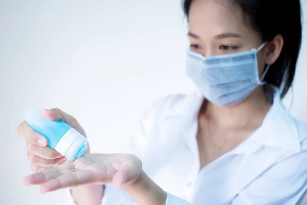 woman wearing hygienic protective mask using wash hand sanitizer alcohol  standing on white background with copy space ,daily protection from corona virus or COVID-19 concept.