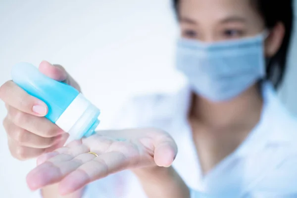 Kadın hijyenik koruyucu maske takıyor çamaşır deterjanı kullanıyor beyaz arka planda fotokopi alanı ile duruyor, Corona virüsüne karşı günlük koruma veya COVID-19 konsepti.