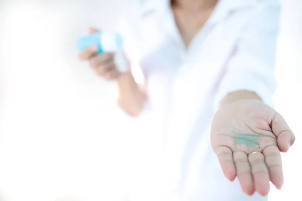 El dezenfektanı kullanan kadın elleri. Alkol jeli pompası. Beyaz arka plan, Corona virüsünden günlük koruma veya COVID-19 konsepti.