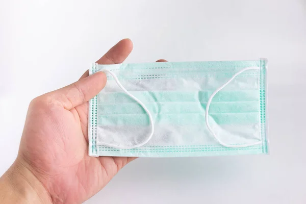 Maskeleri beyaz arka planda tutan el. Mikropları, virüsleri ve Covid-19 'u önlemek için sağlık maskeleri..