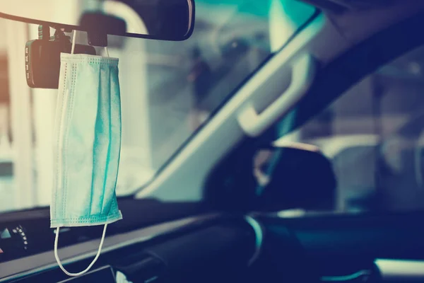 Arabanın ön camında asılı hijyenik maskeler, güneş ışığının geldiği yer. Corona virüsünden ya da COVID-19 konseptinden korunma..