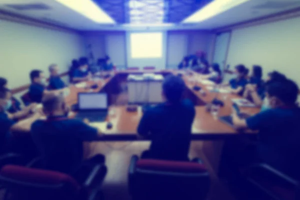 İş adamlarının Coronavirus 'u (Covid-19) toplantı odasında engellemek için maske taktıkları bulanık bir görüntü. Girişim ekibi atölyeyle ilgili beyin fırtınası yapıyor.