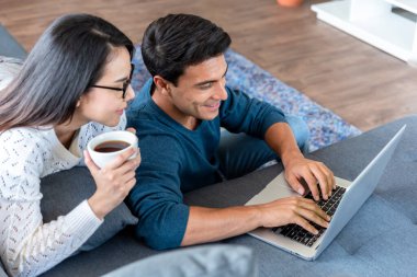 Corona virüsü salgını sırasında evde çalışan çift, internete bağlı dizüstü bilgisayar kullanıyor.