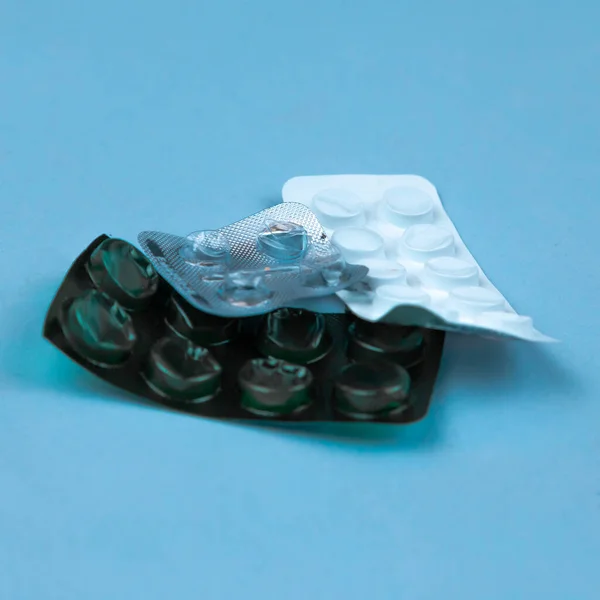 Montón de píldoras médicas en colores blanco y verde. Pastillas en plasti —  Fotos de Stock