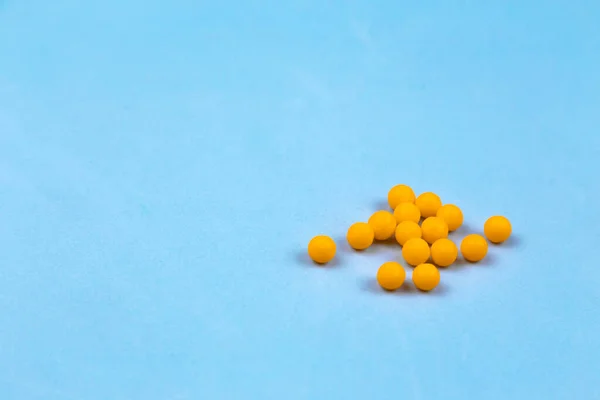 Помаранчеві вітамінні таблетки на синьому фоні крупним планом, з копією sp — стокове фото