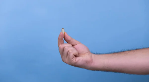 Una pastilla en una mano masculina. Un hombre tiene pastillas en la mano. La conc. — Foto de Stock