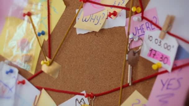 Concepto de búsqueda de amor. Vista de cerca de una junta de detectives con pruebas. En el centro Niñas alfileres de mano una hoja de papel blanco con la inscripción Amor — Vídeos de Stock