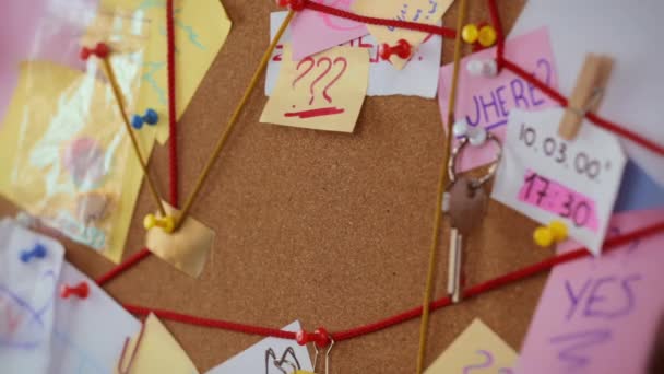 Concepto de búsqueda. Vista de cerca de una junta de detectives con pruebas. En el centro de los alfileres de mano de las mujeres una hoja de papel blanco con la búsqueda de inscripciones — Vídeos de Stock