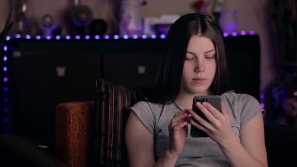 Menina chocada ler mensagem via smartphone. Jovem perturbada segurando celular em casa. Conceito de más notícias — Vídeo de Stock
