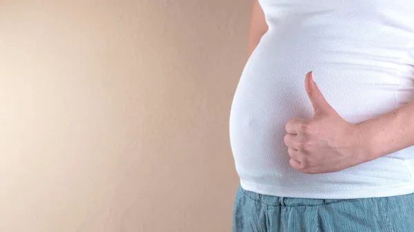 Una visione ravvicinata della pancia di una donna incinta in una T-sh bianca — Foto Stock