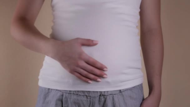 Authentique gros plan d'une jeune femme enceinte en pyjama caressant son ventre vient de se réveiller le matin . — Video