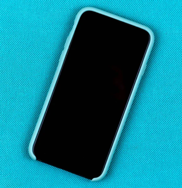 Черный мобильный телефон или смартфон в аква-синем чехле на тризубе — стоковое фото