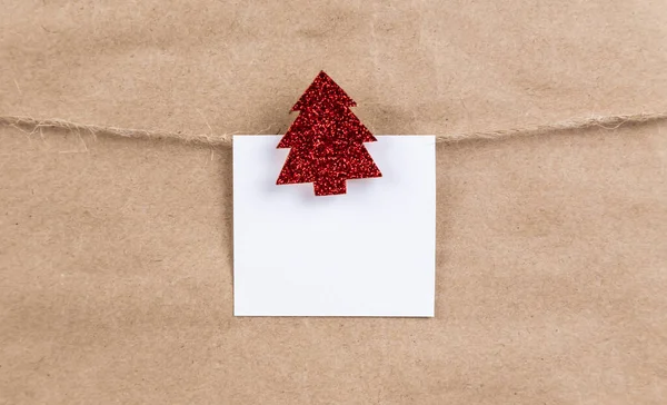 Naklejka papierowa wisząca na linie na drewnianym czerwonym brokatowym Bożym Narodzeniu — Zdjęcie stockowe