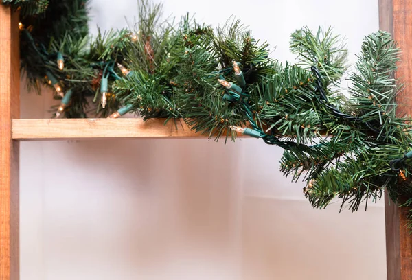 A wooden staircase is decorated with a garland of a Christmas tr — Stock Photo, Image