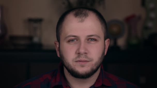 What did you say. Young bearded brutal person of European appearance sits in a chair in a plaid shirt — 비디오