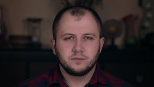 Upset offended young guy of European appearance sits in a chair in a plaid shirt. Emotion concept — 비디오