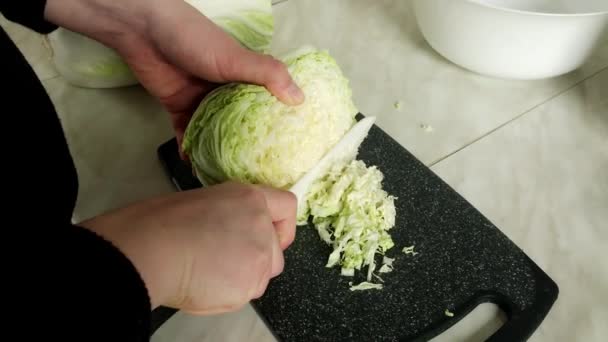 Vrouwen handen snijden een groene kool met mes op houten plank. Sluiten van mes snijdt groenten voor salade. Voedselbereiding — Stockvideo