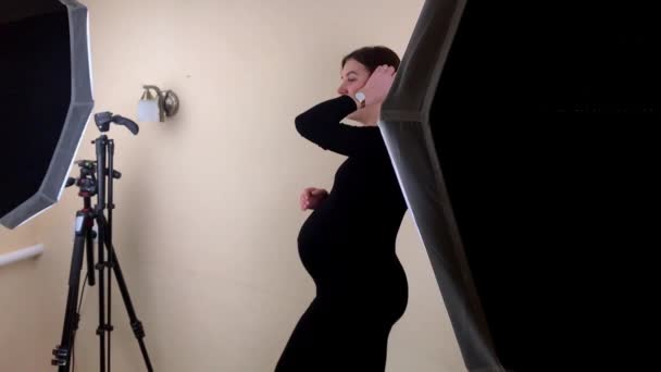 Smuk ung gravid kvinde poserer til fotograf. Gravid fotosession. Venter på en baby – Stock-video