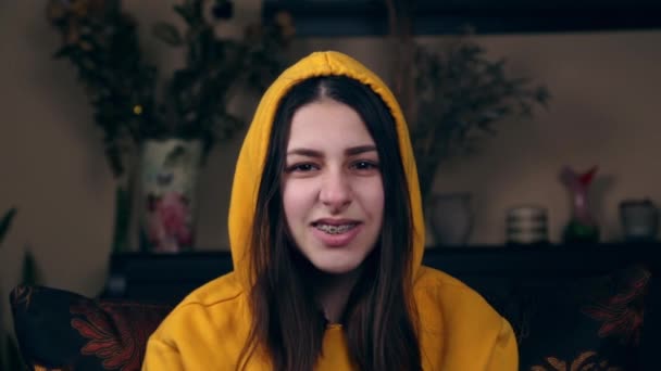 A young girl in a hood and yellow jacket curves and lifts her thumb up. Concept evaluation I like or social like — Stock Video