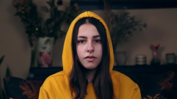 유럽의 젊은 외모의 소녀는 격자무늬 셔츠를 입은 의자에 앉아 자신을 때리고 일어나려고 — 비디오